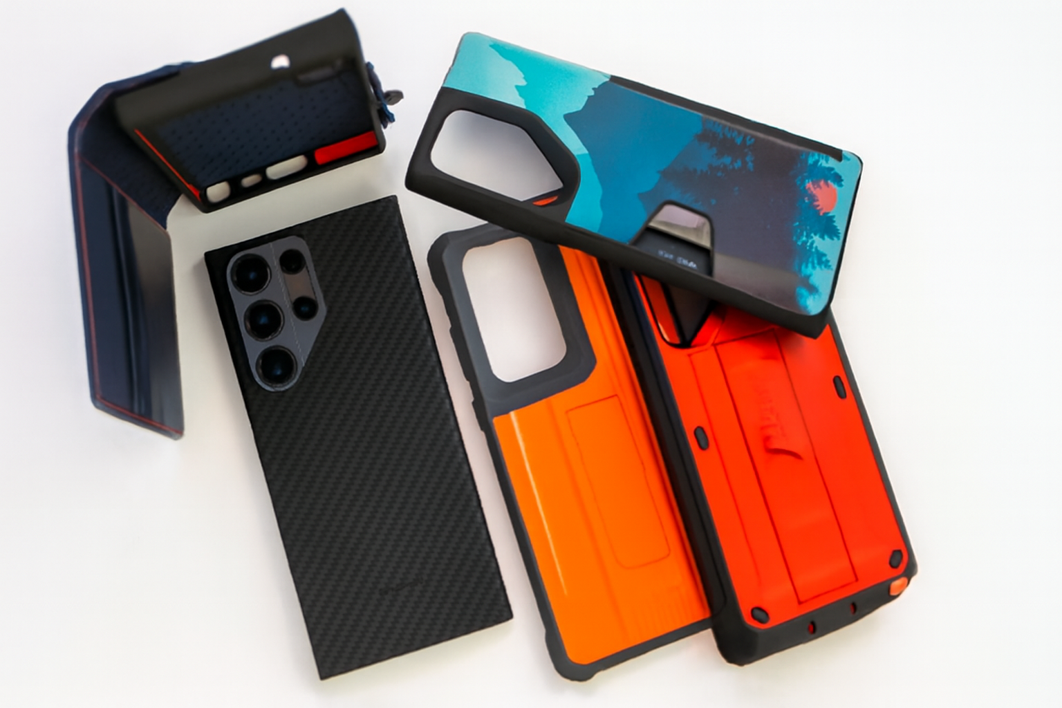 The image showcases a Samsung Galaxy S23 Ultra with a carbon fiber back, accompanied by three protective cases. The cases include a navy folio with red stitching, a rugged orange case, and a case featuring a vivid landscape design. All items are arranged neatly against a white background, highlighting the sleek and modern look of the phone and its cases.